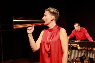 Monica Danielson sjunger i en megafon och Per Sjögren spelar vibrafon