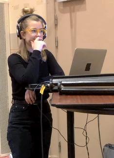 Kajsa Lindgren står vid en dator och övervakar en konsertinspelning