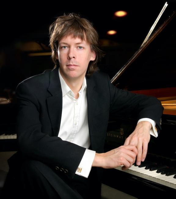 Martin Sturfält lutar sig mot en svart flygel