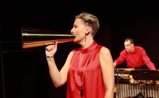Monica Danielson sjunger i en megafon och Per Sjögren spelar vibrafon
